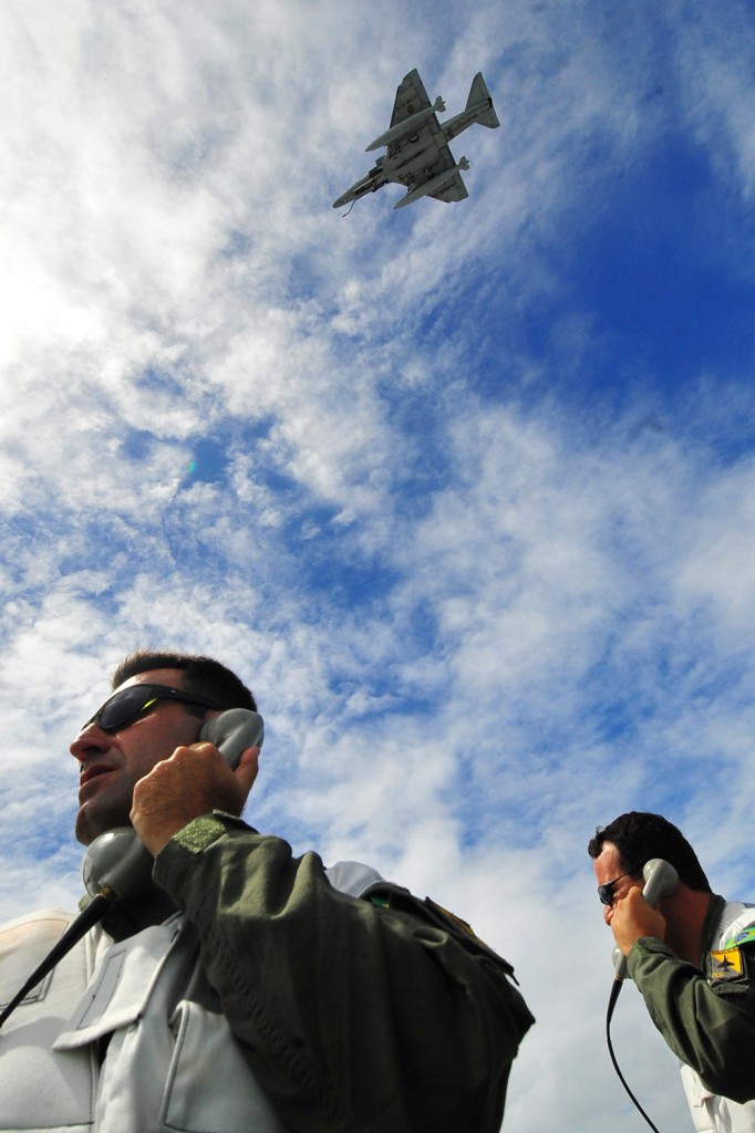 Um Skyhawk da MB passa sobre oficiais brasileiros do Esquadrão VF-1 a bordo do Vinson