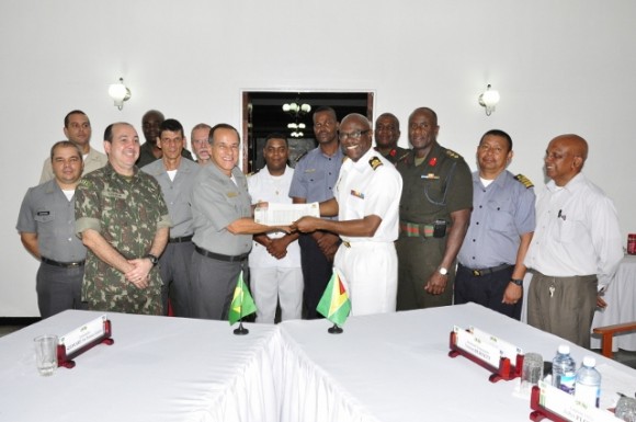 COS Commodore Gary Best and Vice Admiral Ademir Sobrinho exchange signed agreements _In the background are members from both delegations