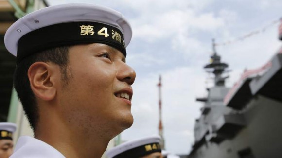 A member of Japan's Maritime Self-Defense Force looks at its new helicopter destroyer DDH183 Izumo before its launching ceremony in Yokohama