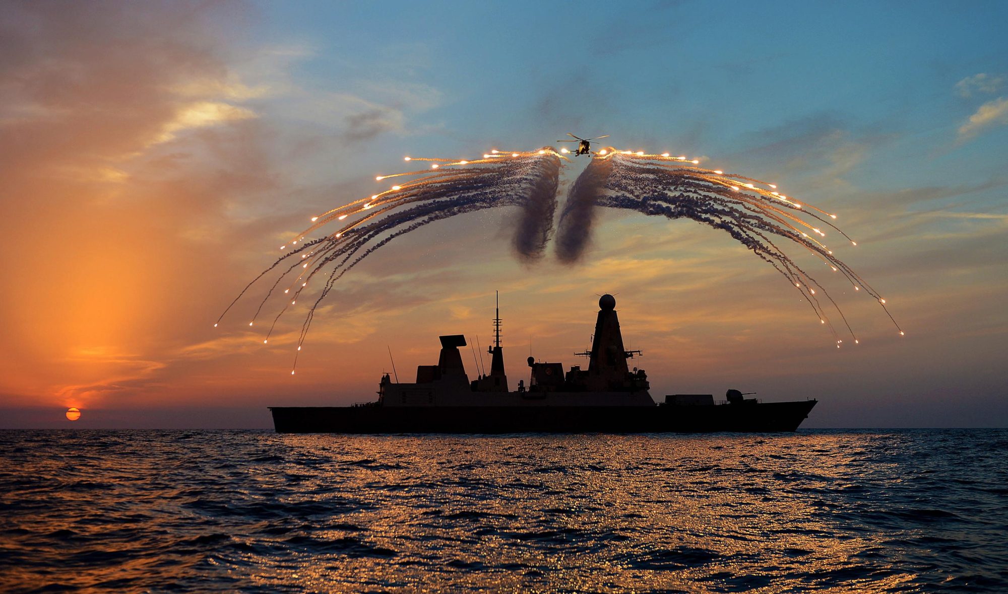 Helicóptero Lynx lançando flares sobre um destróier Type 45 da Royal Navy